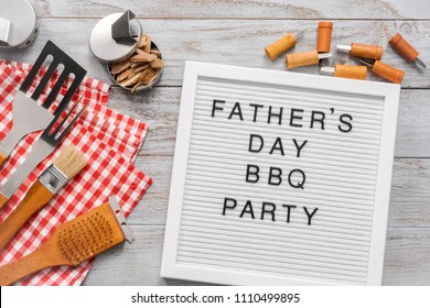 Father's Day BBQ Party Sign On A White Memo Board With Cooking Tools.