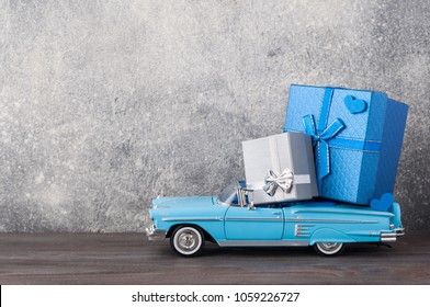 Father's Day Concept. A Toy Car With Gifts, Heart, 19th Of July On Wooden Background. Copy Space For Fathers Day Greeting Card.