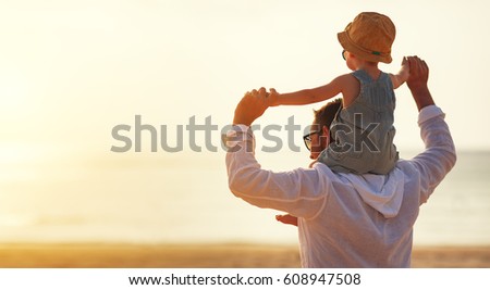 father's day. Dad and baby son playing together outdoors on a summer beach