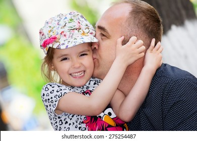 Father's Day. Dad Kissing His Daughter.Happy Smiling Child With Parent. Family Portrait.