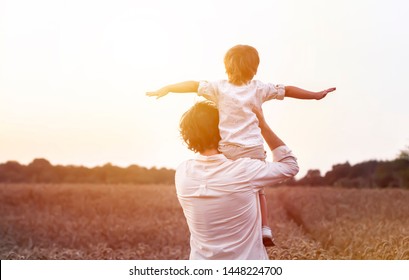 father's day. Dad and son playing together outdoors on a summer. Happy family, father, son at sunset. The concept of organic farming and healthy lifestyle,  happiness and joy - Shutterstock ID 1448224700