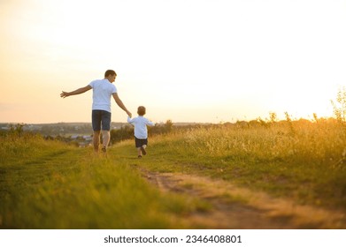 father's day. Dad and son playing together outdoors on a summer. Happy family, father, son at sunset - Powered by Shutterstock