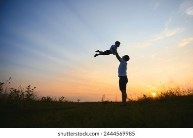 father's day. Dad and son playing together outdoors on a summer. Happy family, father, son at sunset - Powered by Shutterstock