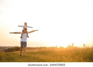 father's day. Dad and son playing together outdoors on a summer. Happy family, father, son at sunset - Powered by Shutterstock