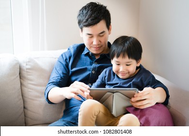 Father's Day Family Concept. Asian Boy Is Watching A Tablet. Father Taught Social Learning From Around The World To His Son. Or What The Children Do Not Understand. It Is A Good Family Relationship. 