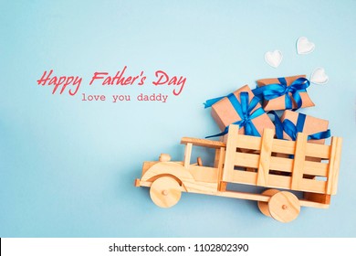 Father's Day greeting message with wooden toy truck with gift box in the back on blue background. Happy fathers day concept. - Powered by Shutterstock