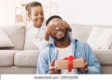 Father's day. Happy daughter congratulating dad and giving present at home - Shutterstock ID 1391762783