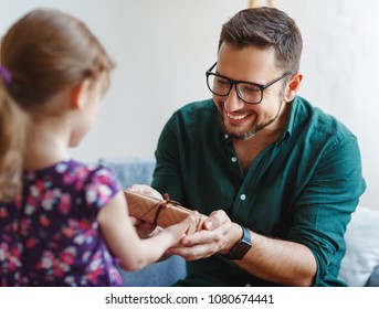 Father's Day. Happy Family Daughter Giving Dad A Gift On Holiday
