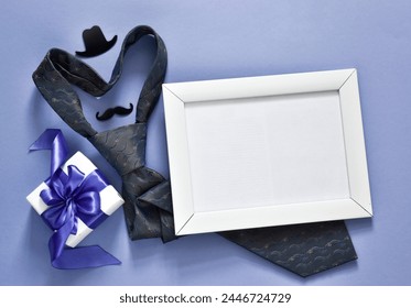 Father's Day idea. Blank frame for text with necktie, eyeglasses, hat, mustaches and gift box on a violet background. Empty photo frame for text or your photo - Powered by Shutterstock