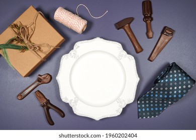 Father's Day Or Masculine Birthday Table Setting Commenorative Plate Flatlay Styled With Gift, Chocolate Tool Set And Tie. White Product Mock Up With Negative Copy Space For Your Text Or Design Here.