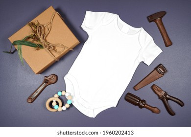 Father's Day Or Masculine Birthday Theme Baby Romper Onesie Flatlay Styled With Gift, Chocolate Tool Set And Tie. White Product Mock Up With Negative Copy Space For Your Text Or Design Here.