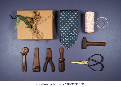 Father's Day Or Masculine Birthday Theme Flatlay Background Styled With Gift, Chocolate Tool Set And Tie. Blog Hero Header Creative Composition.