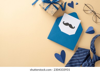 Father's Day is the perfect time to showcase a top view of hearts, glasses, blue necktie, open envelope, postcard with mustaches, and a gift box on a beige background featuring an empty space for text