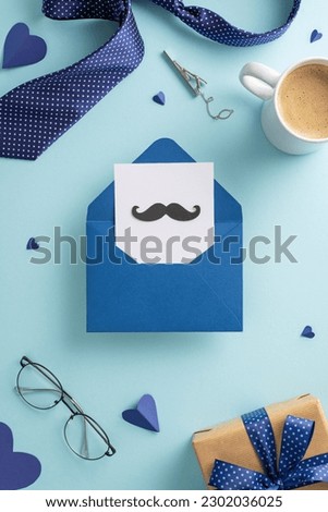 Father's Day surprise idea. Top view vertical of open envelope, postcard with mustaches, coffee mug, tie, glasses, craft paper giftbox with bow, and other men's accessories on pastel blue background