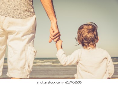 Father's hand lead his child son in summer beach nature outdoor, trust family concept