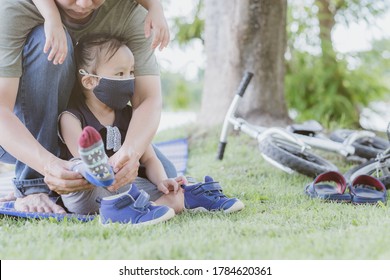 Father's Hands Tying His Little Daughter's Shoes. Copy Space.