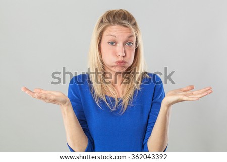 fatigue or boredom concept - frustrated young blond woman puffing her cheeks out for resignation and disillusion with hand gesture,studio shot