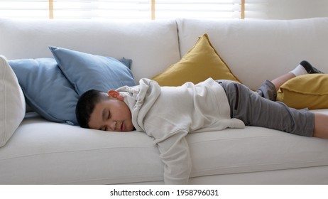 Fatigue in children laying fall down asleep slumber on sofa at home need rest or brain break after virtual study online remote learn at home problem in asian kid feel lack of energy and tired. - Powered by Shutterstock