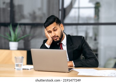 Fatigue, Chronic Sleep Deprivation. Sleepy Arabian Or Indian Business Man In A Suit, Sit At Workplace In Office With A Laptop, Put His Head On His Hand, Fell Asleep During Work, Feels Tired