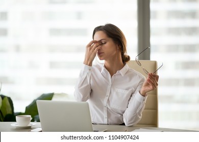 Fatigued businesswoman taking off glasses tired of computer work, exhausted employee suffering from blurry vision symptoms after long laptop use, overworked woman feels eye strain tension problem - Powered by Shutterstock