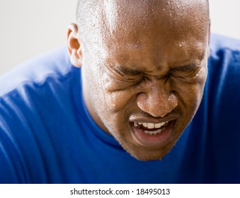 Fatigued Man Dripping Sweat And Grimacing