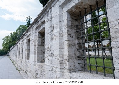 Fatih, Istanbul, Turkey - 07.05.2021: historical stone walls of Suleymaniye mosque and iron window barriers positioned geometrically and sidewalk near