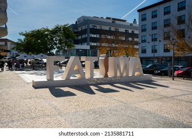 Fatima, Portugal - November 13 2022 - People Enjoying The Sun On A Square Next To The Name Sign Of Town