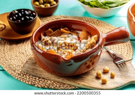 Fattet Hummus with chick peas served in dish isolated on wooden table side view of middle eastern food