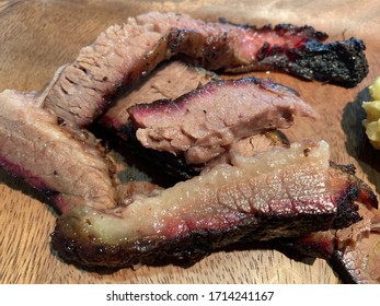 Fatty BBQ Brisket On A Wooden Plate Background.