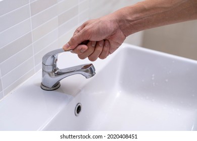 The faucet in the bathroom with running water. Man keeps turning off the water to save water energy and protect the environment. save water concept
