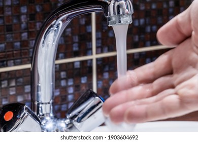 Faucet At Domestic Bathroom With Low Water Pressure. Person Check Water Temperature To Adjust It. Leaky Tap Repair.