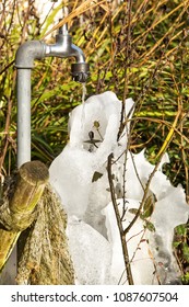 Faucet With Frozen Water, Outdoor Shot Of Ice Under A Steel Water Faucet