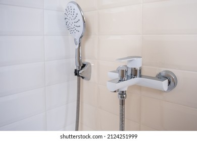 Faucet For Hot And Cold Water, With A Shower Hose, Mounted In A Wall  In The Bathroom. A Modern Bathroom