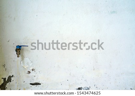 a faucet on old dirty concrete wall, water tab on cracks dirty wall with copy space