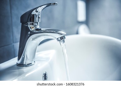 Faucet and water drop close up. Bathroom interior with sink and water tap. - Shutterstock ID 1608321376