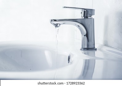 Faucet And Water Drop Close Up. Bathroom Interior With Sink And Water Tap.