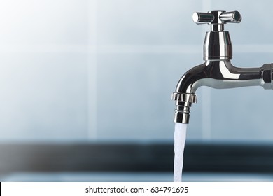 faucet and water flow on bathroom - Shutterstock ID 634791695
