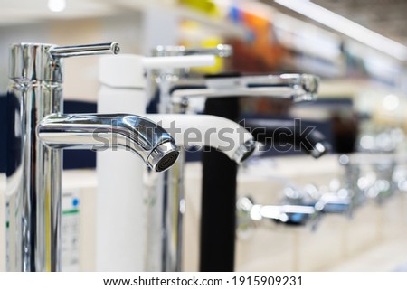 Faucets on a showcase in a store. An assortment of sanitary ware in a specialized trade network. Close-up. Copy space