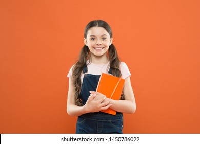 Favorite Book. Happy Little Girl With Notebook. Reading Book. Literature Lesson. Back To School. School Girl On Orange Background. Kid Diary. Writing Notes. Poetry And Novel. Modern Education.