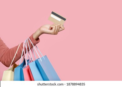 Favorite Goods, Clothing Sale And Online Shopping. Hand Of Millennial African American Female Holding Many Color Packages And Credit Card, Isolated On Pink Background, Free Space, Studio Shot