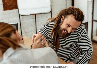 Favourite Activity. Joyful Bearded Man Smiling While Doing Armwrestling With His Colleague