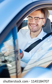 Favourite Occupation. Delighted Happy Man Smiling While Enjoying Driving In His Car