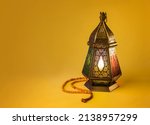 Fawanis. Traditional Ramadan lantern with prayer beads on bright yellow background. Clear space for text.