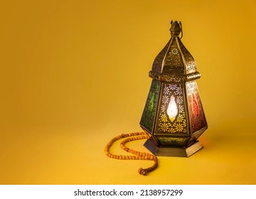 Fawanis. Traditional Ramadan lantern with prayer beads on bright yellow background. Clear space for text.