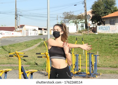 Fazenda Rio Grande, Parana, Brazil. June 23th, 2020.
Woman Wearing Mask, Doing Exercise In A Park, During Covid 19 Pandemic.
In The Background Says: FazenGas, It Means Advertisement For Cooking Gas.