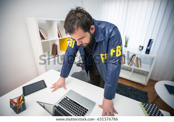 Fbi Agent In His Office Working On A Case And Using Laptop