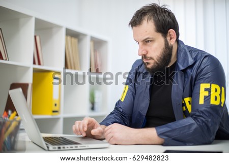 FBI agent working in his office working on laptop