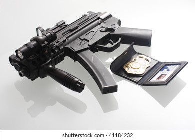 An FBI Badge And Assault Gun On A Table.