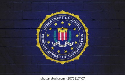 La bandera del FBI (Oficina Federal de Investigación) pintada en una pared de ladrillo.