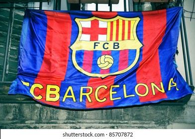 a FC Barcelona flag hanging on a balcony